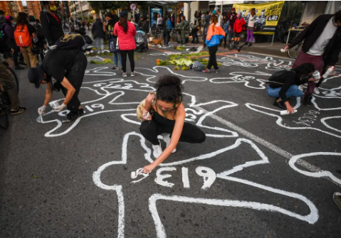 Personas pintando siluetas en la calle frente a la Jurisdicción Especial para la Paz en Bogotá