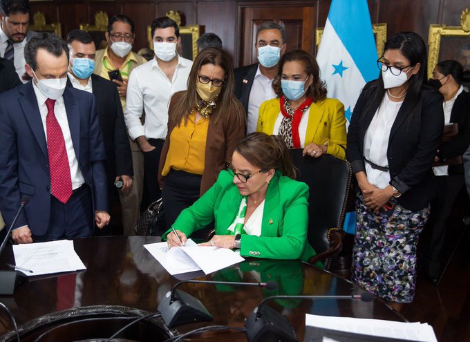 Presidenta de Honduras firmando documento