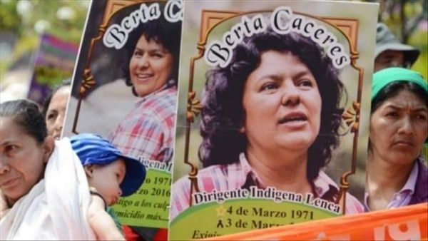 Personas con pancartas con el rostro de Berta Cáceres