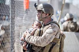 Militar alzando a niña en brazos