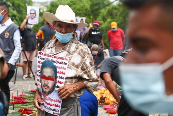 Hombre en manifestación sostiene cartel