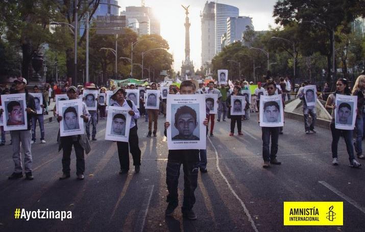 Manifestaci&oacute;n. Se muestran personas con pancartas con las fotograf&iacute;as de los desparecidos en Ayotzipa