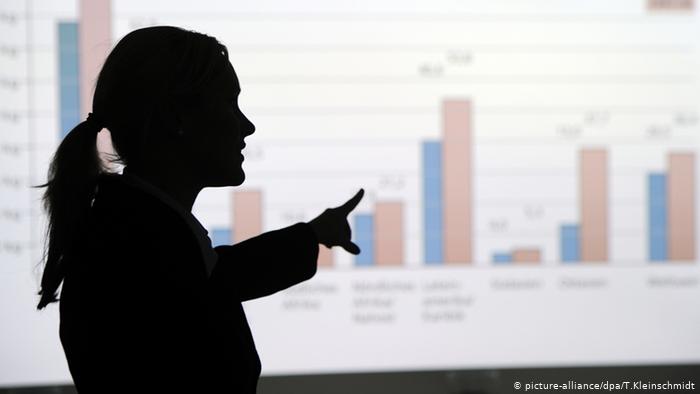 Imagen de mujer a contra luz en una presentación con gráficos