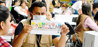 Hombre mostrando una papeleta electoral en Honduras