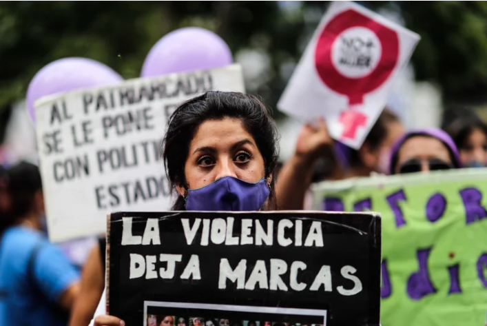 Mujer con pancarta "La violencia deja marcas"