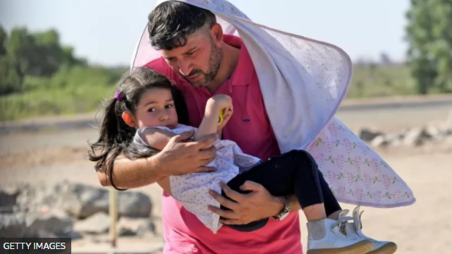 Hombre con niña en brazos