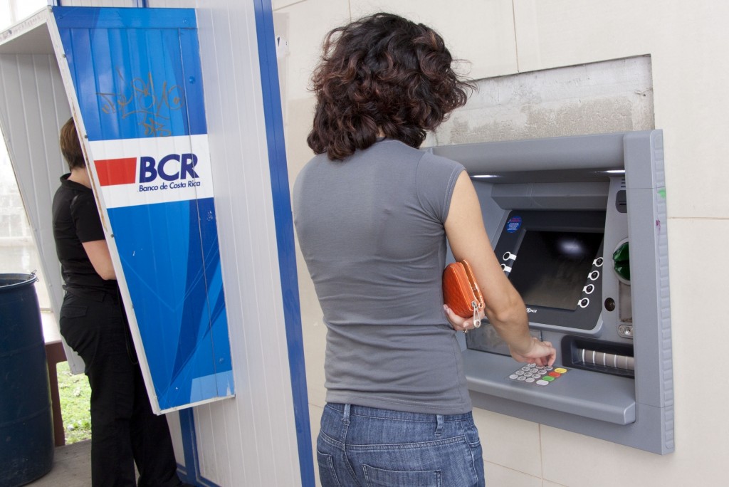 Fotografia de mujer sacando dinero de un cajero automático