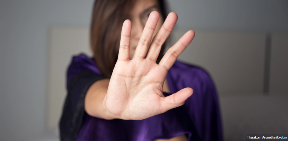 Mujer colocando la palma de la mano frente a la cámara