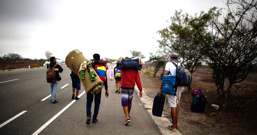 Personas caminan con sus pertenencias en un bolso