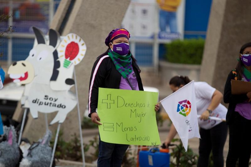 Mujeres integrantes de una organización feminista sostienen carteles durante un plantón para conmemorar el Día de la Mujer de Honduras