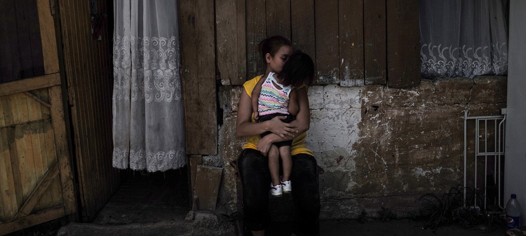 Mujer migrante sostiene a ni&ntilde;o en brazos