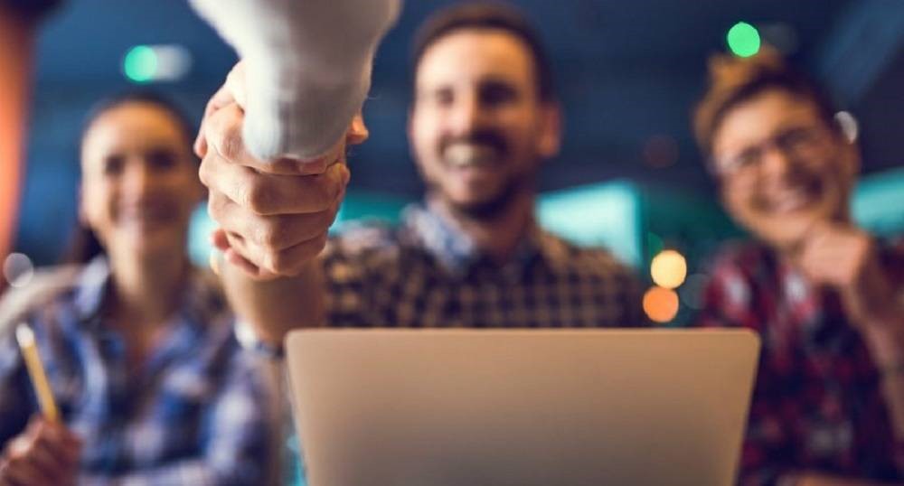 Jov&eacute;nes extendiendo la mano