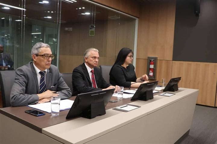 Tres personas sentadas en escritorio