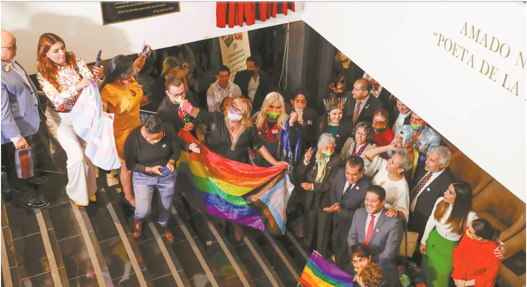 Personas unidas con banderas de la comunidad LGBTIQ+