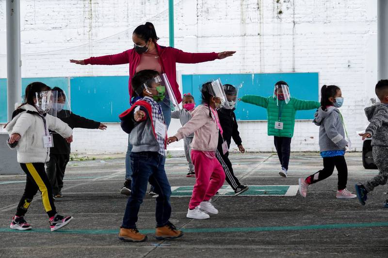 Niños y niñas jugando con mujer adulta