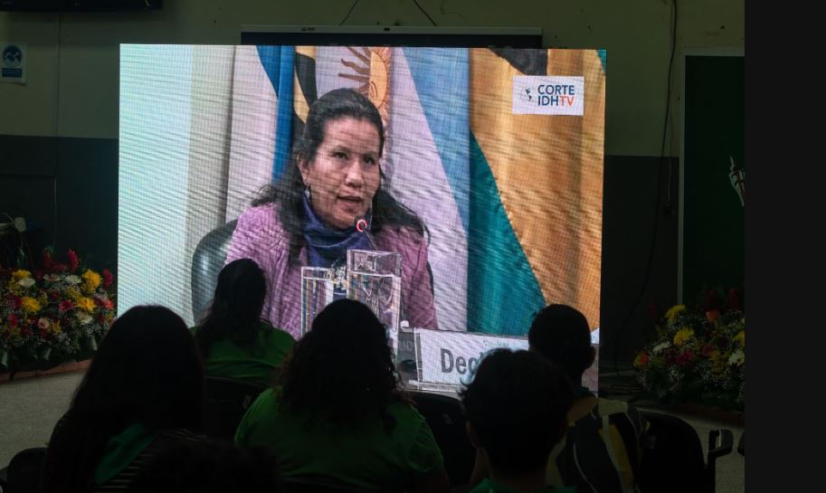 Imagen de la proyección de una mujer testificando