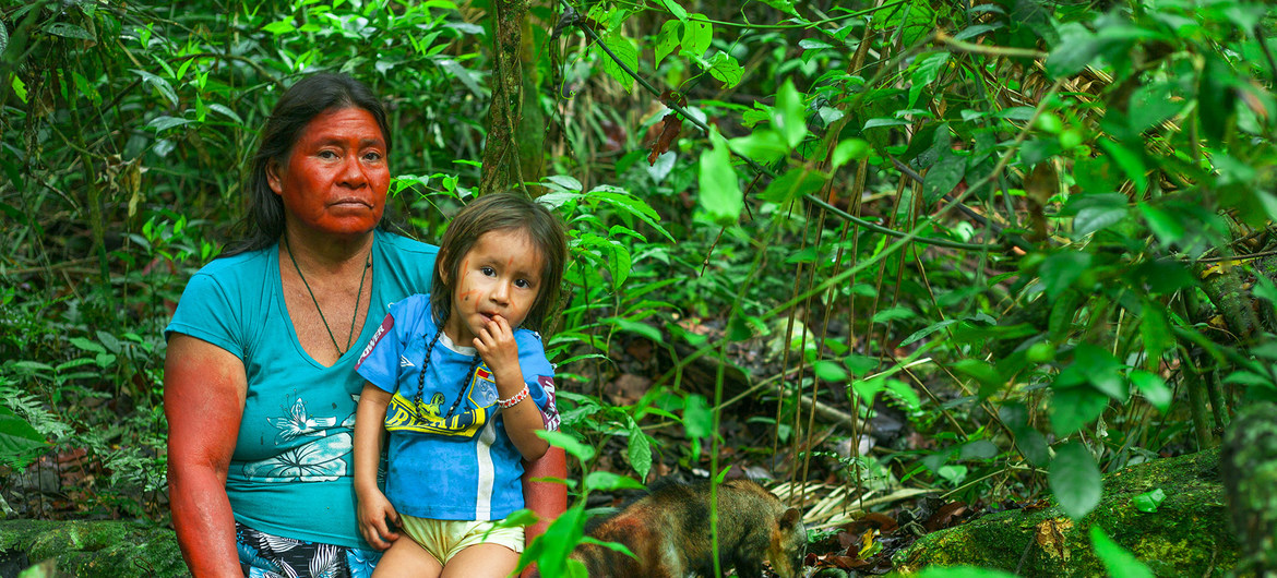 Indigena Peruana alzando a niño