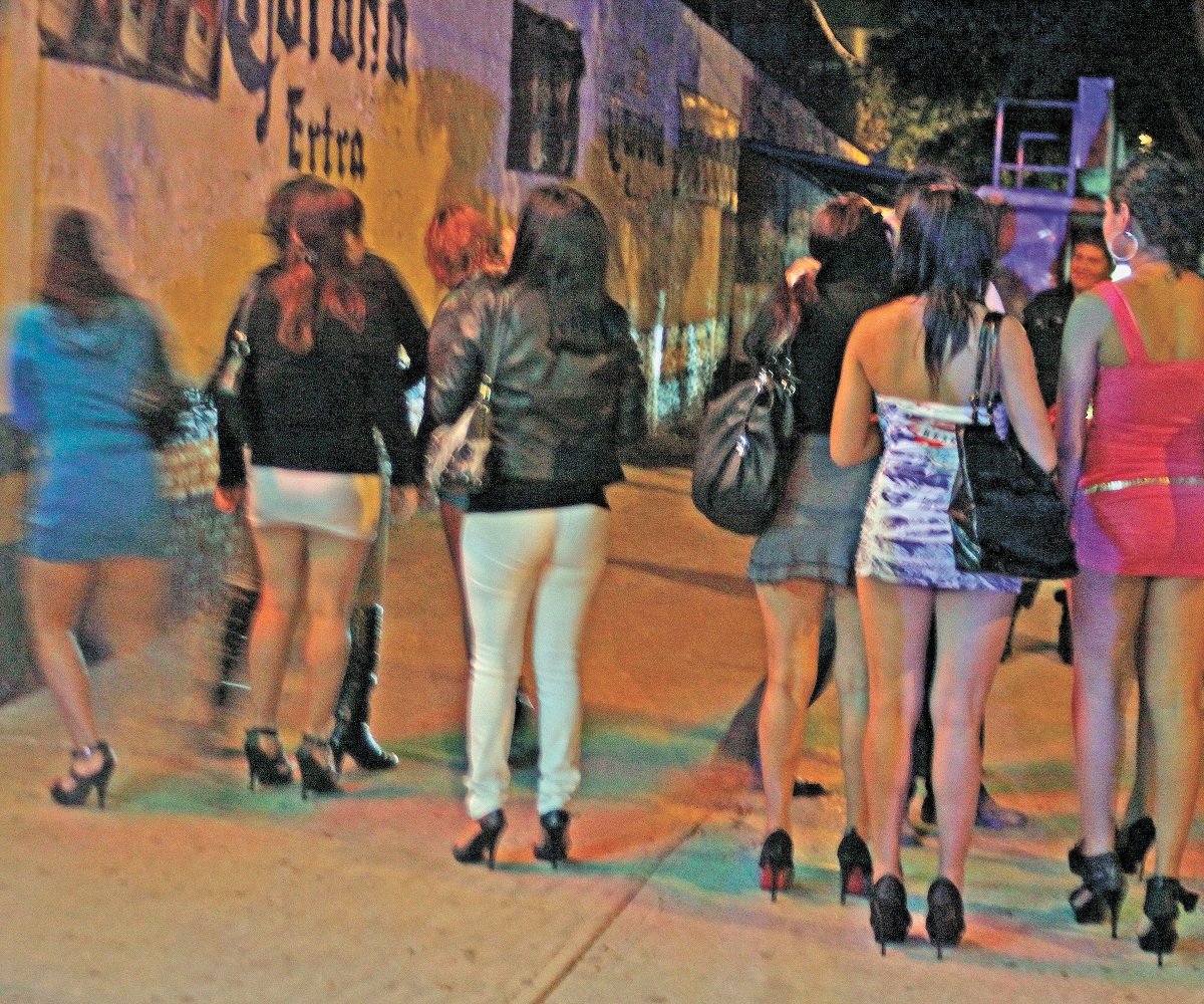 Grupo de mujeres en una acera a horas de la noche