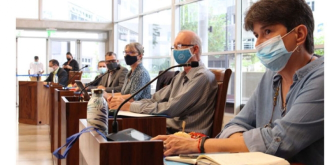 Ocho personas en espacio de cub&iacute;culos con micr&oacute;fonos.