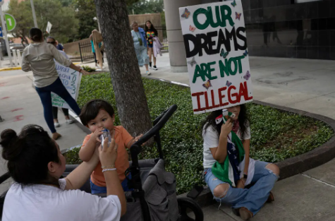 Familia Protestando con un cartel, el cual dice "Nuestros sueños no son ilegales".