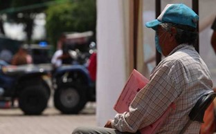 adulto sentado en banca, vía pública