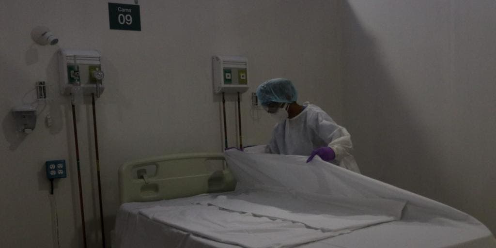 Persona con equipo m&eacute;dico en cuarto oscuro.