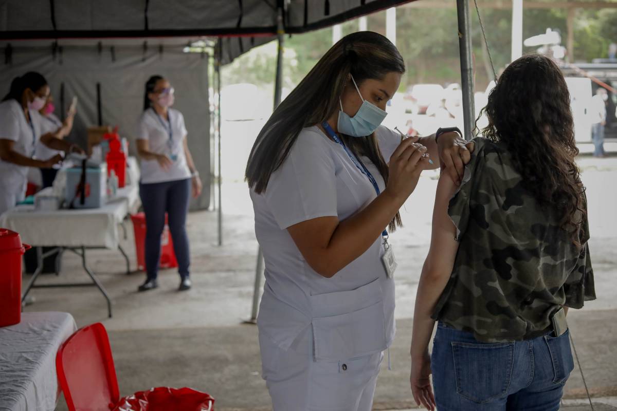 Enfermera aplicando vacunación a joven