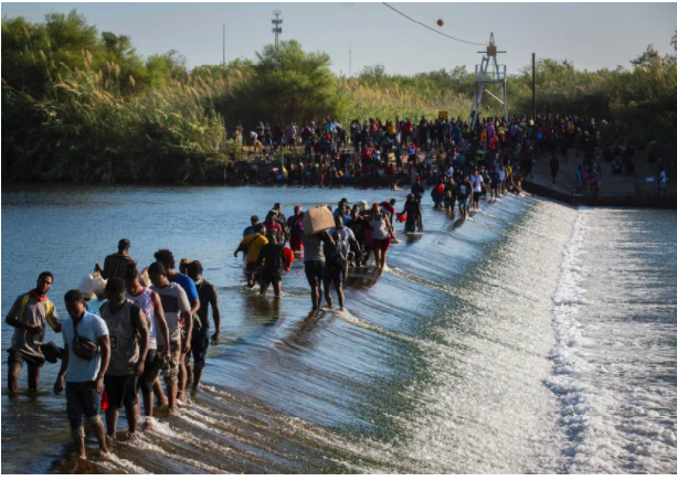 Migrantes provenientes de Haiti cruzando río