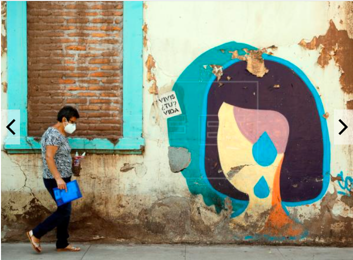 Mujer caminando frente a mural en Tegucigalpa